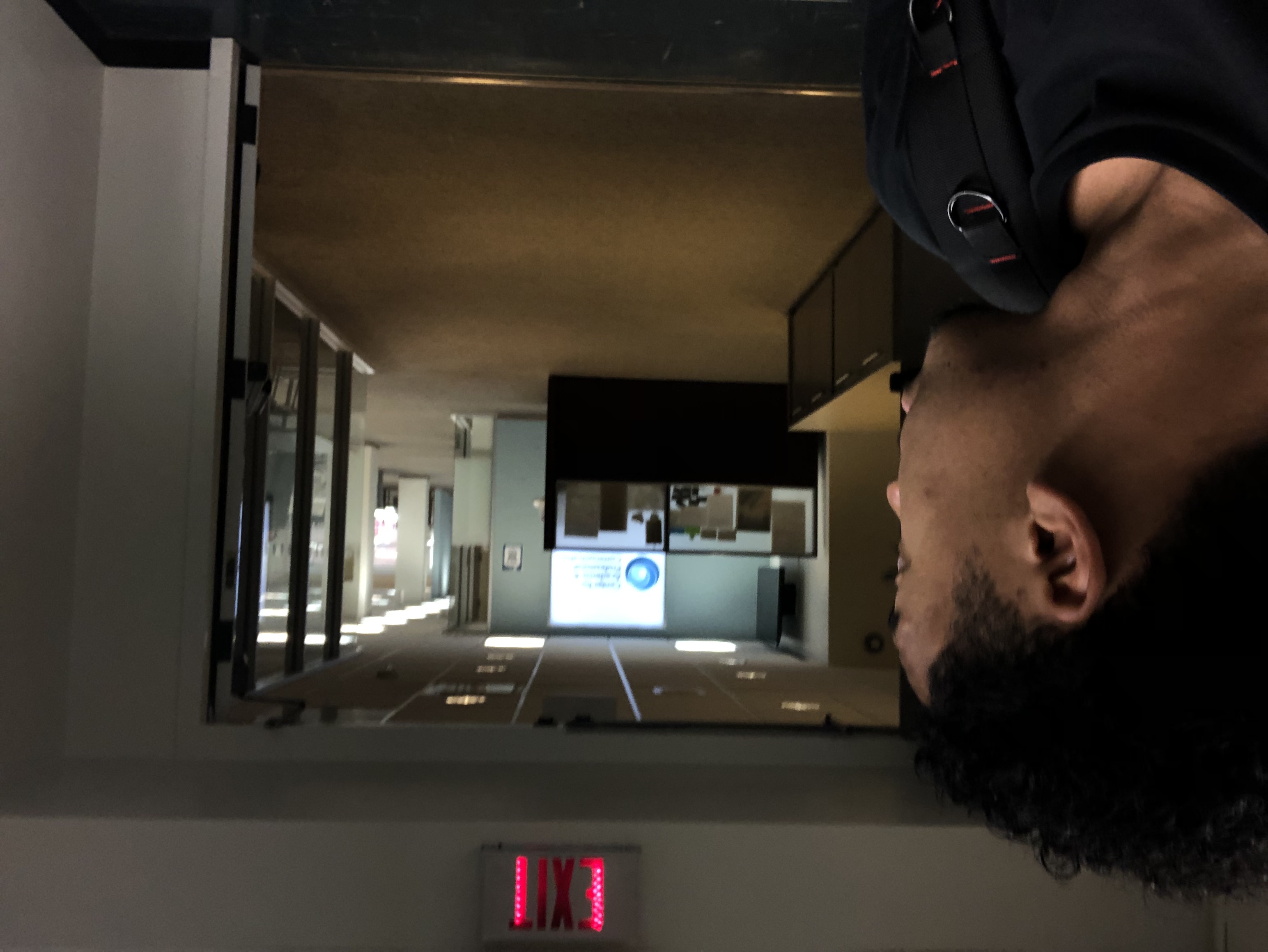 student in a darkened library hallway