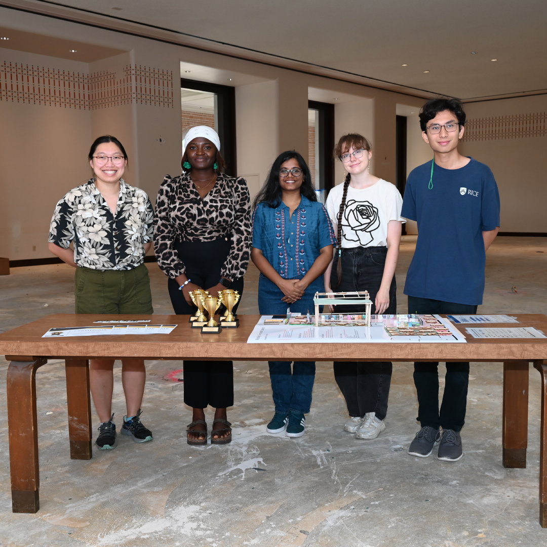 five winners standing at a table with trophies in the unrenovated north reading room