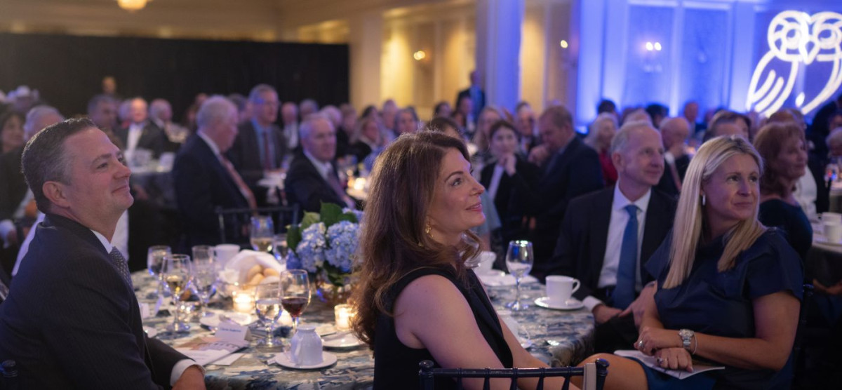 attendees of the gala are seating and looking at a speaker