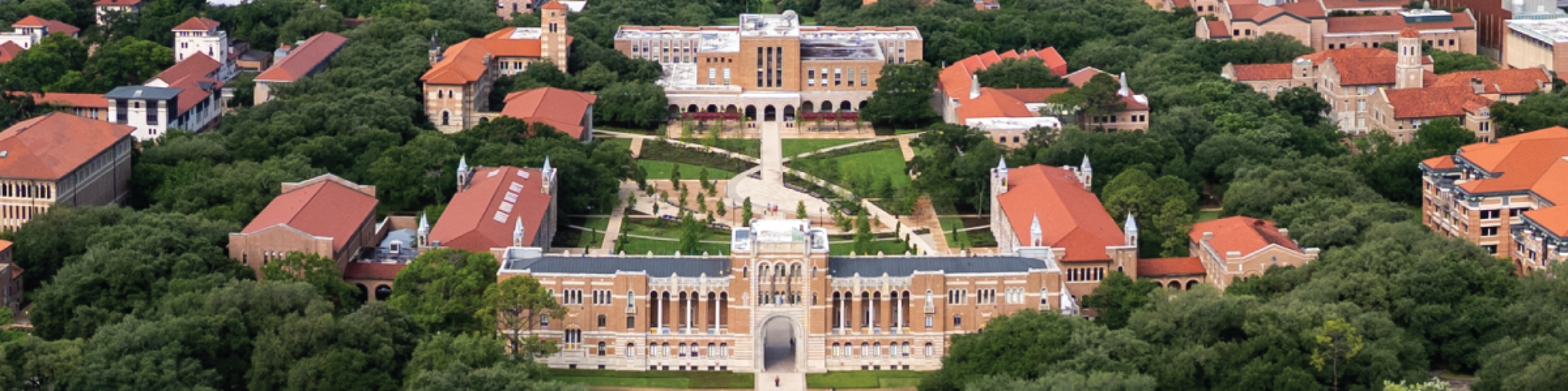 Wide aerial panorama of Rice University's academic quad, with Lovett Hall's archway in the foreground and Fondren Library in the background, connected by a central walkway through green lawns, surrounded by red-tile-roofed buildings and dense tree canopy.
