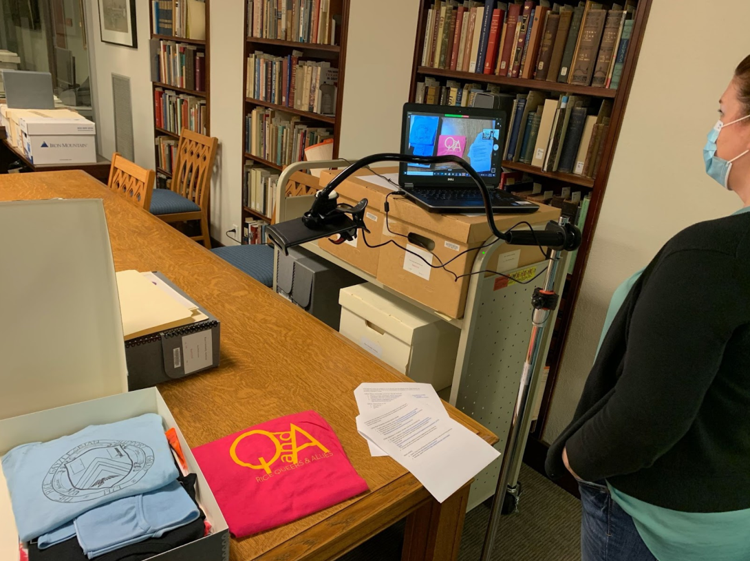 Woodson staff displaying archival material through a webcam and laptop computer