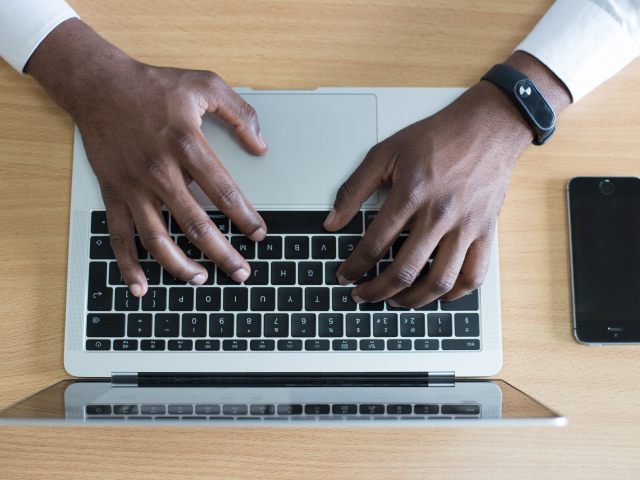 Overhead of hands using a laptop